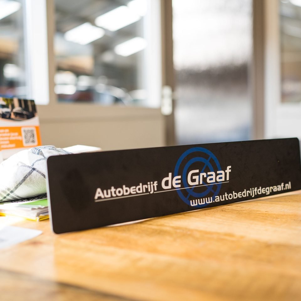 Bureau met het naambord van Autobedrijf De Graaf